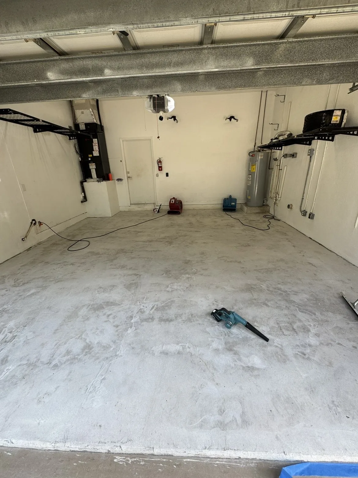 Worn concrete workshop garage floor drying before flake system